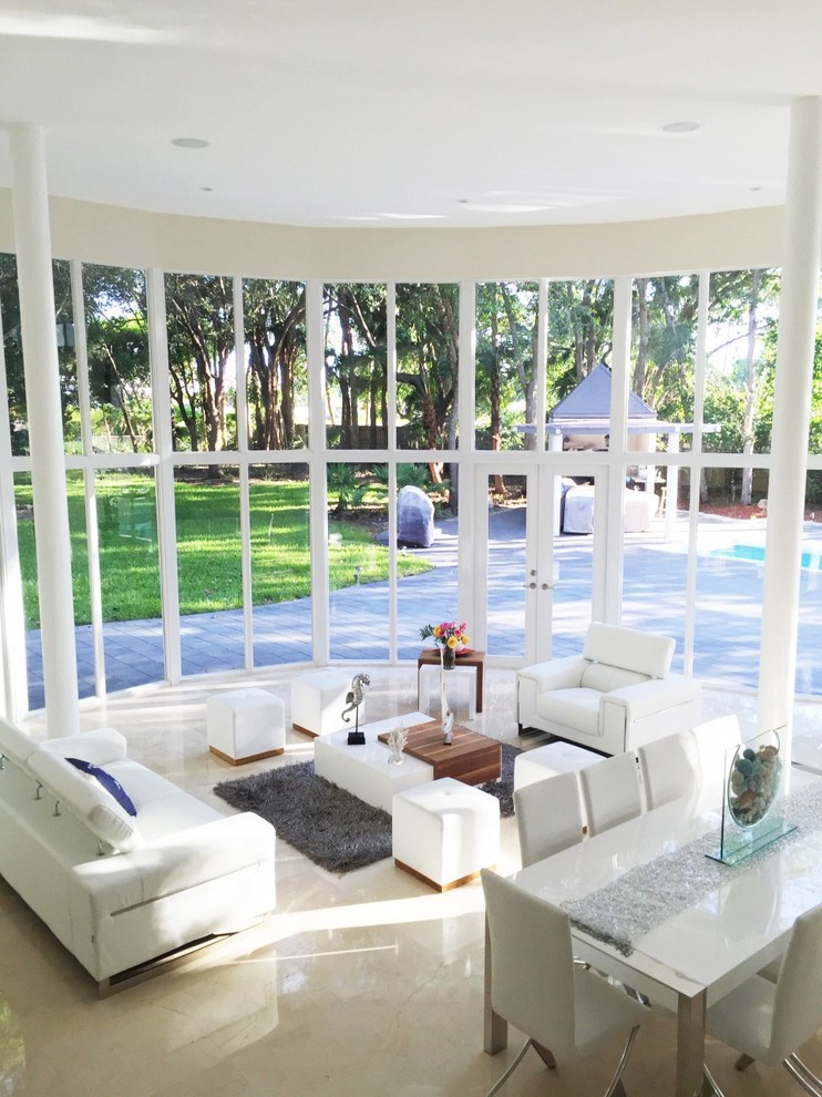 This is an example of a modern conservatory in Miami with marble flooring and beige floors.