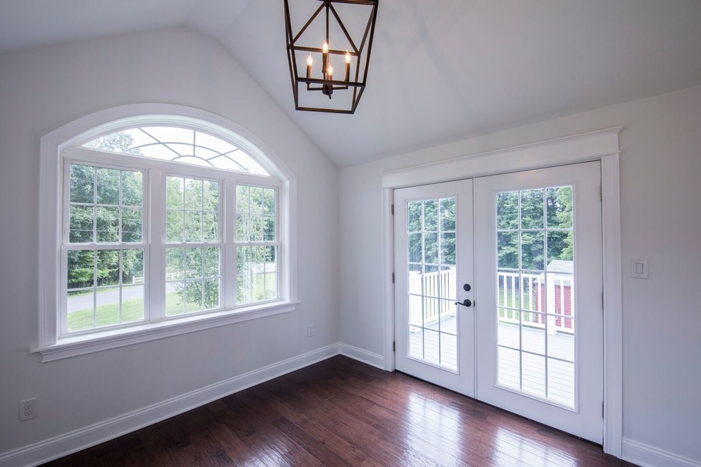 This is an example of a medium sized traditional conservatory in New York with dark hardwood flooring, no fireplace, a standard ceiling and brown floors.