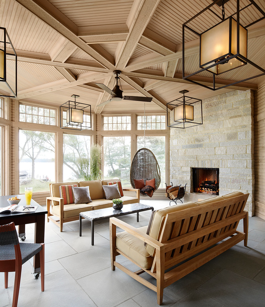 Ispirazione per una grande veranda tradizionale con cornice del camino in pietra, soffitto classico e pavimento grigio