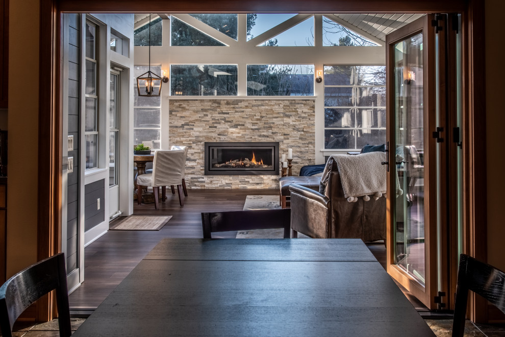 Inspiration for a large transitional vinyl floor and brown floor sunroom remodel in Other with a standard fireplace, a stone fireplace and a standard ceiling