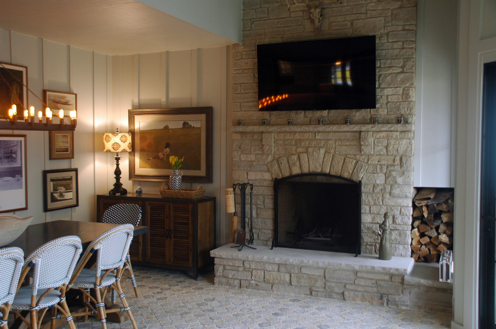Cette image montre une très grande véranda rustique avec tomettes au sol, une cheminée standard, un manteau de cheminée en pierre et un plafond standard.