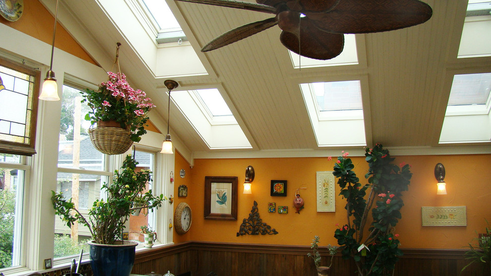 Inredning av ett lantligt litet uterum, med travertin golv, takfönster och flerfärgat golv