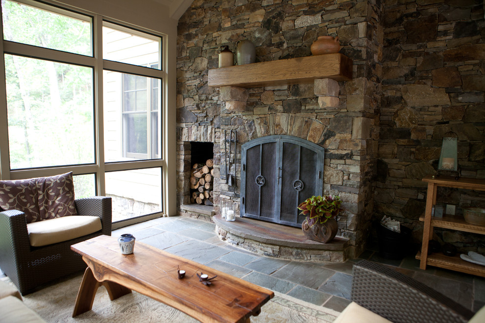 This is an example of a large rustic conservatory in Other with slate flooring, a standard fireplace, a stone fireplace surround and a standard ceiling.