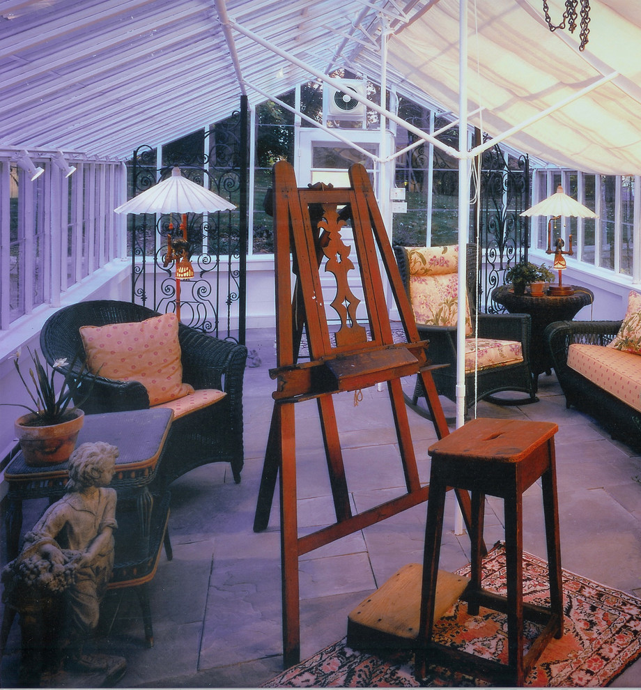 Idée de décoration pour une grande véranda bohème avec un sol en ardoise et un plafond en verre.