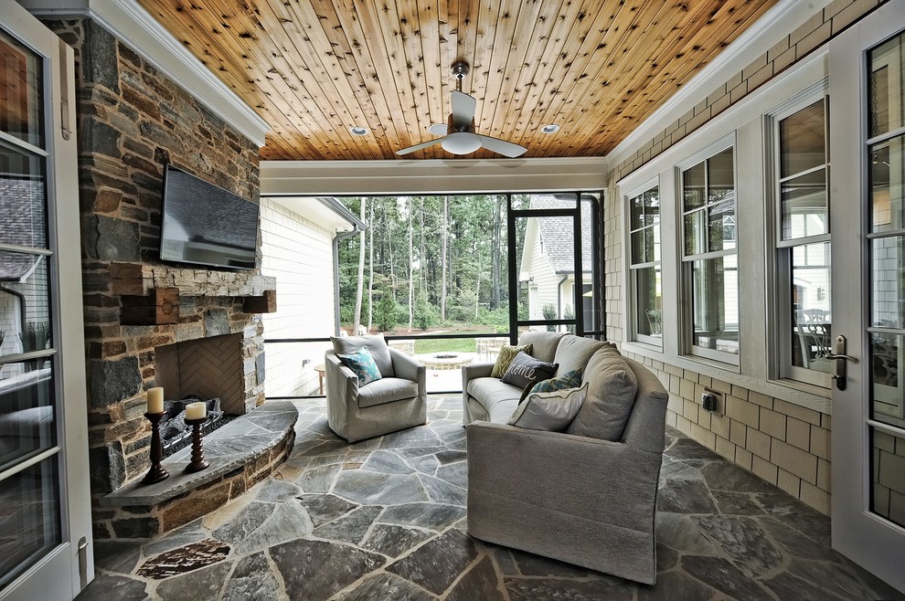 Esempio di una veranda stile americano di medie dimensioni con camino classico, cornice del camino in pietra, soffitto classico, pavimento in ardesia e pavimento grigio