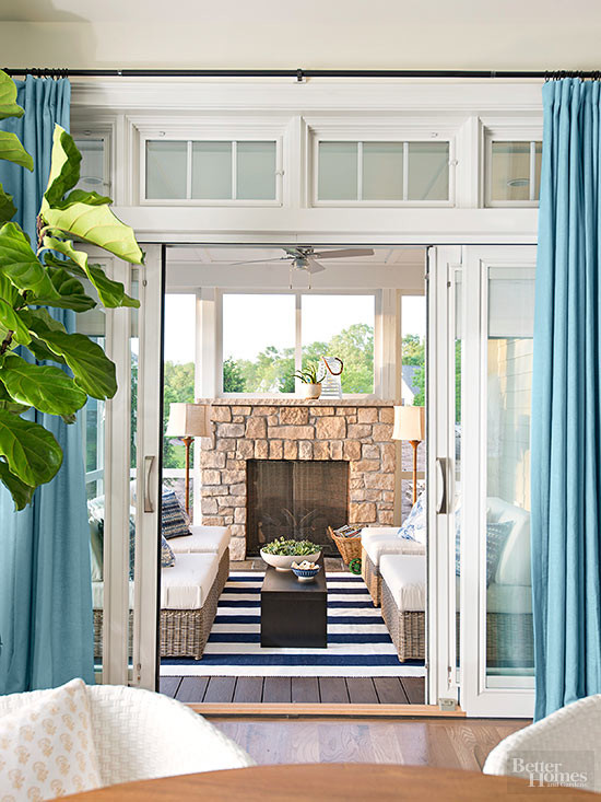 Idee per una veranda contemporanea con parquet scuro, camino classico, cornice del camino in pietra e soffitto classico
