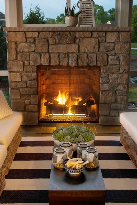 Cette photo montre une véranda tendance avec parquet foncé, une cheminée standard, un manteau de cheminée en pierre et un plafond standard.