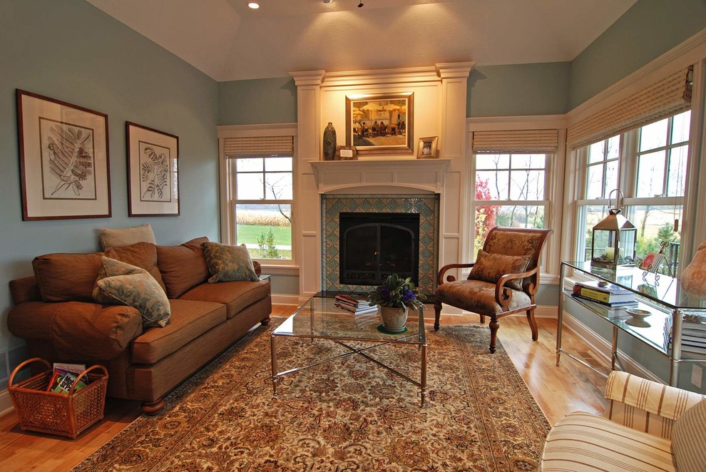 This is an example of a traditional conservatory in Minneapolis with light hardwood flooring, a tiled fireplace surround and a standard ceiling.