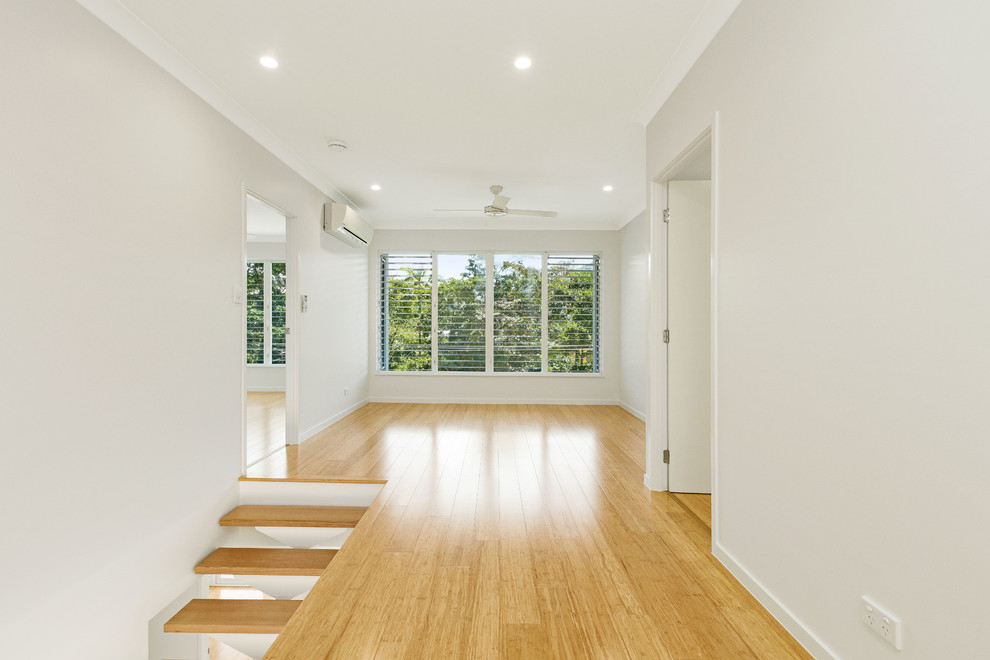 Modelo de galería minimalista de tamaño medio sin chimenea con suelo de bambú y techo estándar