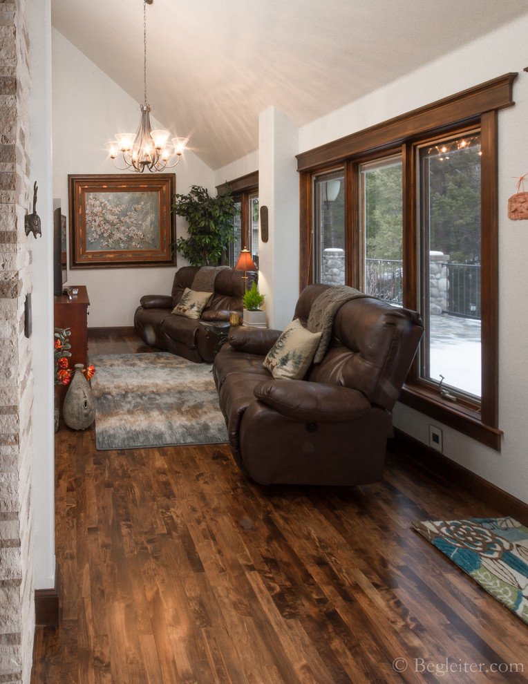 Small transitional medium tone wood floor sunroom photo in Other with a standard fireplace, a stone fireplace and a standard ceiling
