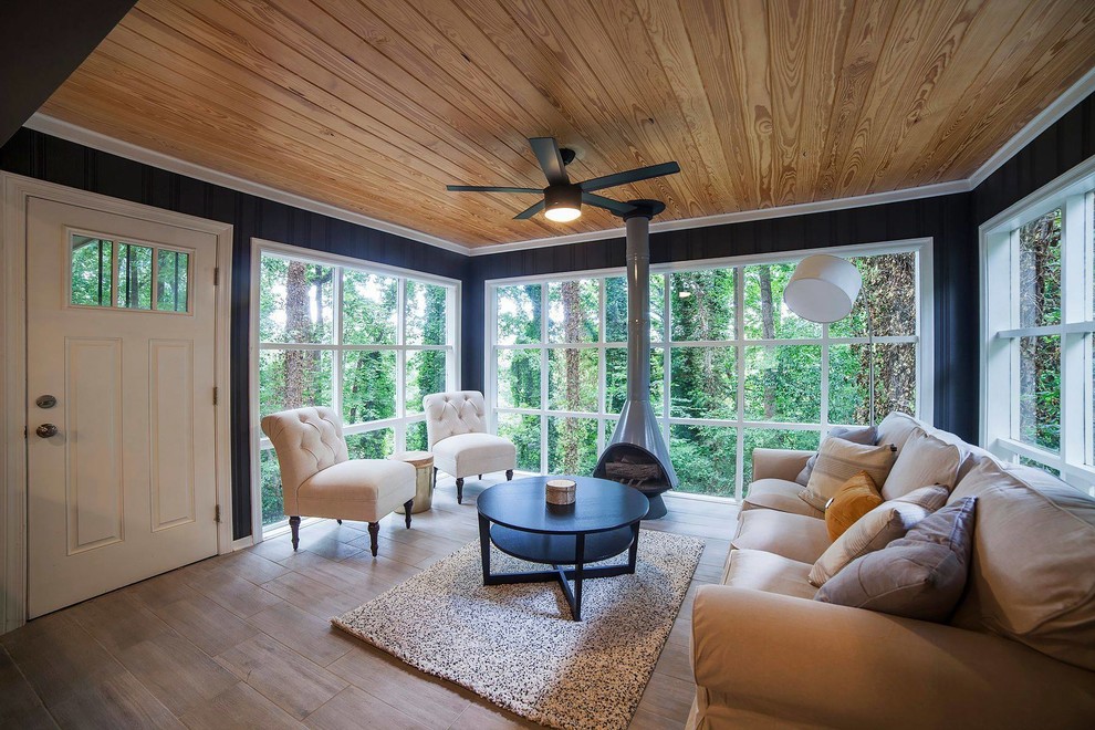 Foto di una veranda minimal di medie dimensioni con pavimento in gres porcellanato, camino sospeso, cornice del camino in metallo, soffitto classico e pavimento marrone