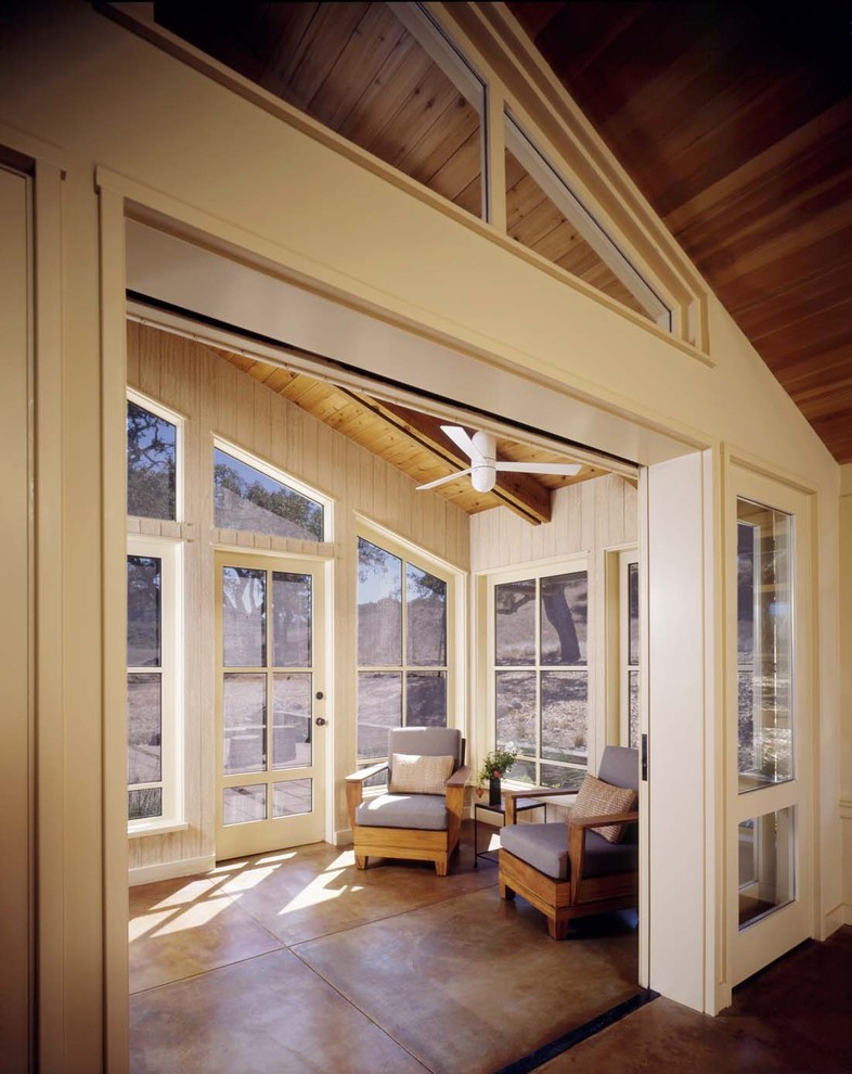 Ejemplo de galería de estilo de casa de campo con techo estándar, suelo de cemento y suelo marrón