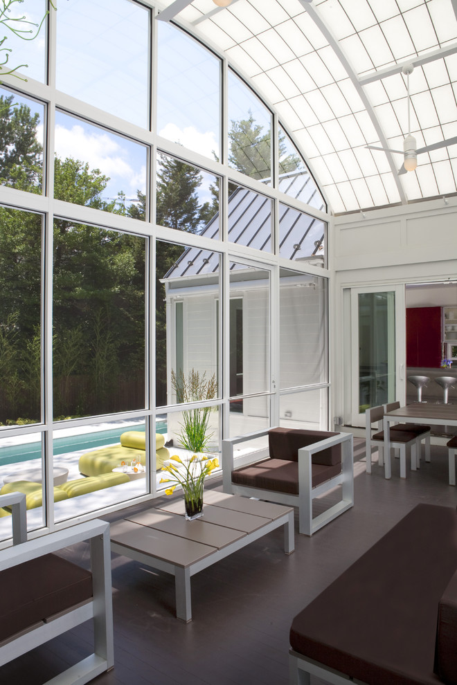 This is an example of a large traditional conservatory in DC Metro with dark hardwood flooring and a glass ceiling.