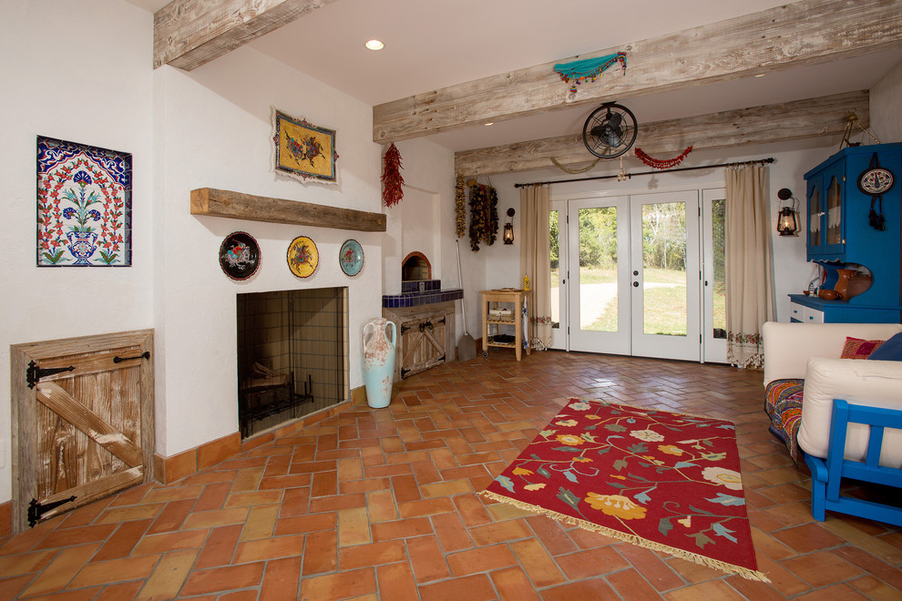 ワシントンD.C.にある地中海スタイルのおしゃれなサンルーム (テラコッタタイルの床、薪ストーブ、タイルの暖炉まわり、標準型天井、オレンジの床) の写真