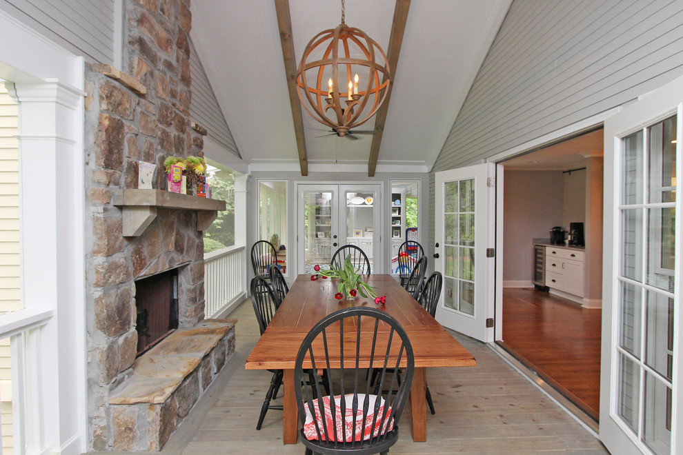 Foto di una grande veranda tradizionale con parquet chiaro, camino classico, cornice del camino in pietra, soffitto classico e pavimento grigio