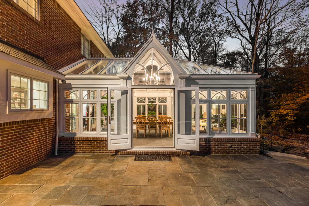 Immagine di una grande veranda classica con pavimento in travertino e soffitto in vetro