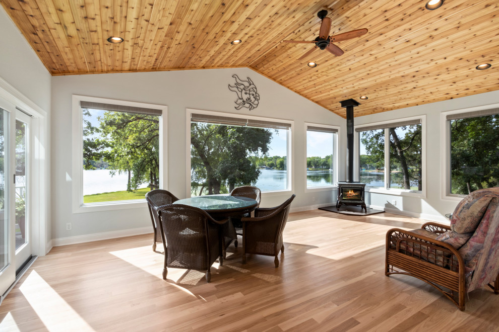 Immagine di un'ampia veranda classica con stufa a legna, parquet chiaro, soffitto classico e pavimento beige