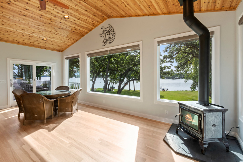 Ispirazione per un'ampia veranda chic con parquet chiaro, stufa a legna, soffitto classico e pavimento beige