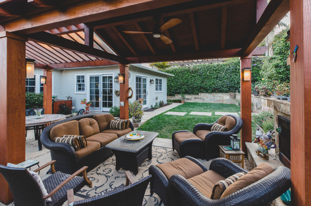 This is an example of a small world-inspired conservatory in Santa Barbara with concrete flooring, a standard fireplace, a stone fireplace surround, a standard ceiling and grey floors.