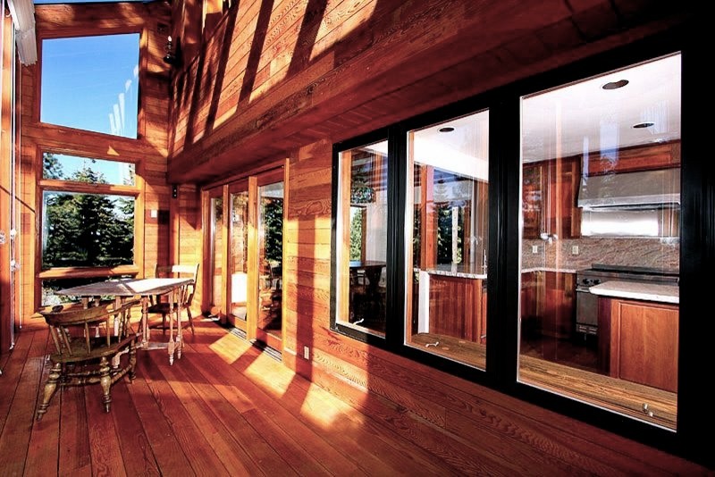 Foto de galería rural de tamaño medio sin chimenea con suelo de madera en tonos medios y techo con claraboya