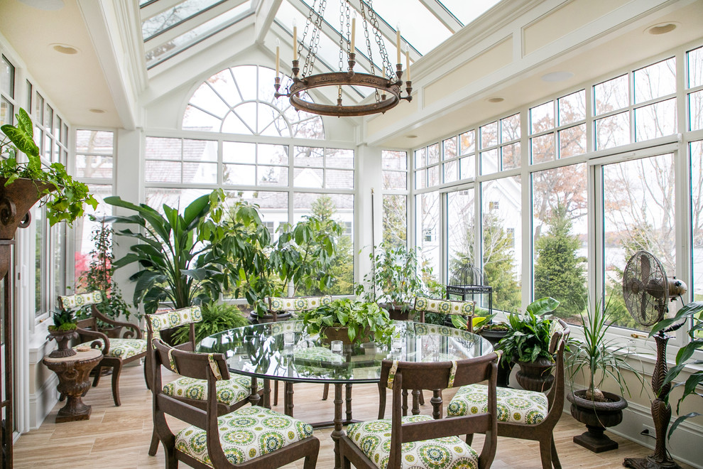 This is an example of a large traditional conservatory in Milwaukee with medium hardwood flooring, a glass ceiling, brown floors and no fireplace.