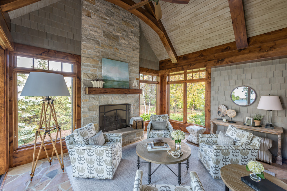 This is an example of a large classic conservatory in Minneapolis with a standard fireplace and a stone fireplace surround.