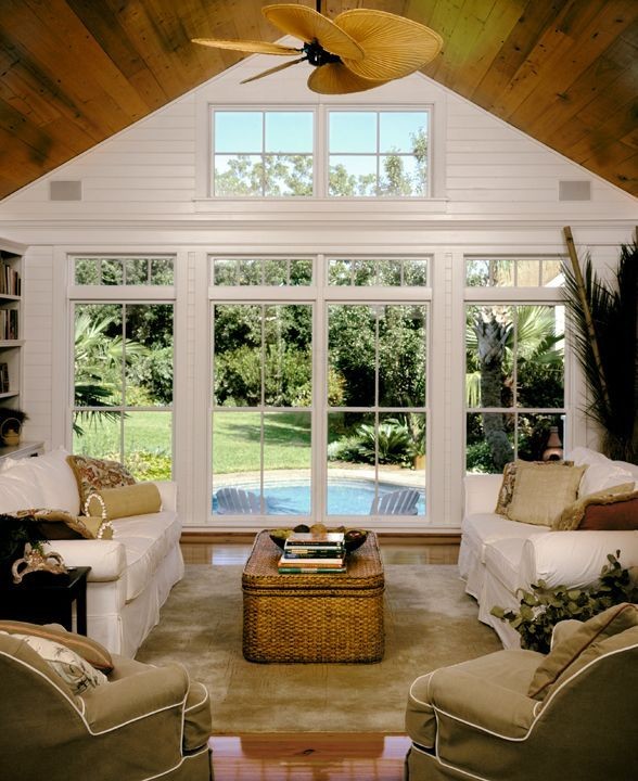 Immagine di una veranda costiera con pavimento in legno massello medio e soffitto classico