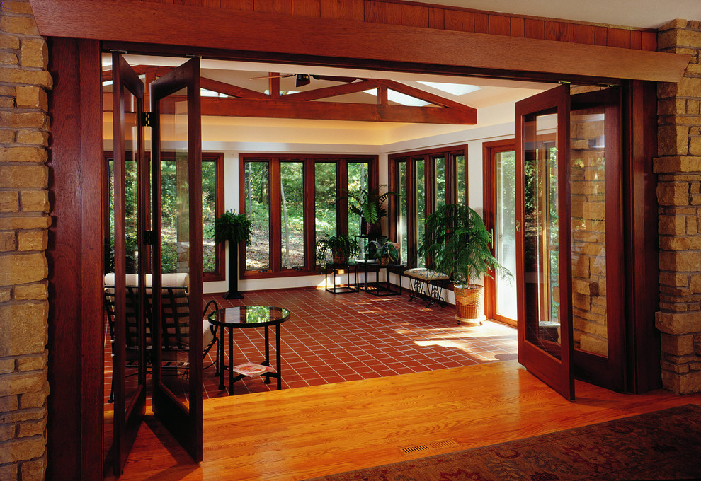 Medium sized traditional conservatory with ceramic flooring, a skylight and brown floors.