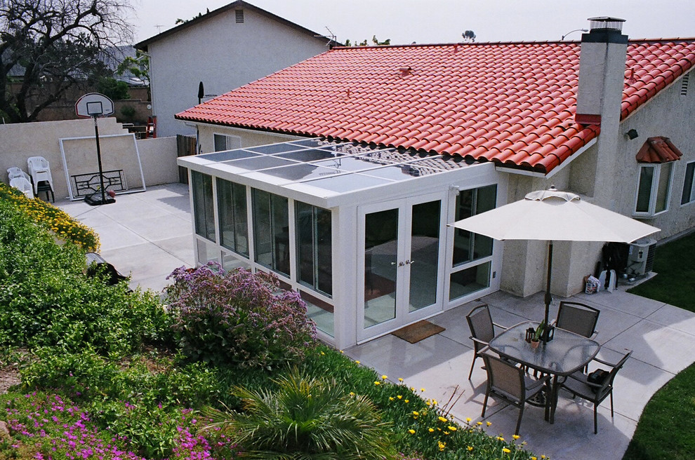 Immagine di una piccola veranda moderna con pavimento in gres porcellanato, nessun camino e soffitto in vetro