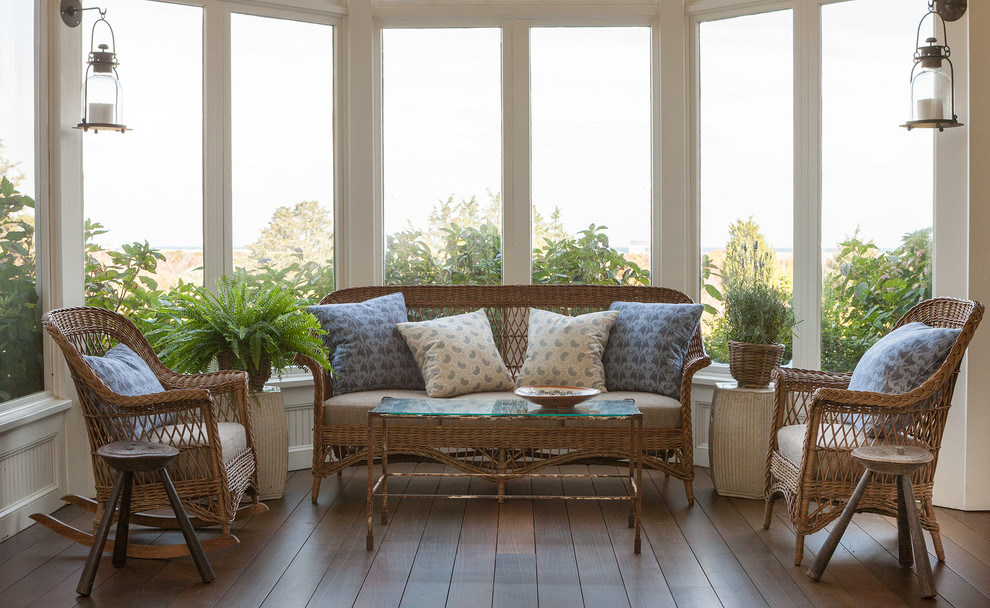 Immagine di una grande veranda stile marino con parquet scuro, nessun camino, cornice del camino in mattoni e soffitto classico