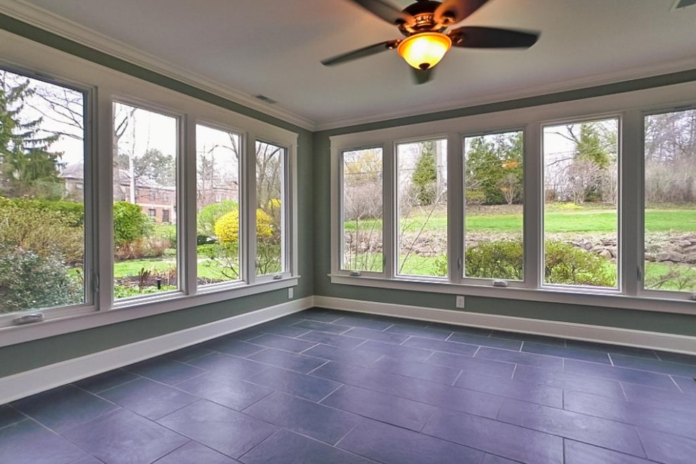 Photo of a midcentury conservatory in Cleveland with ceramic flooring and black floors.