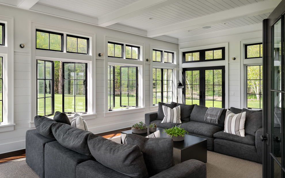 Immagine di una grande veranda country con parquet scuro, soffitto classico e pavimento marrone