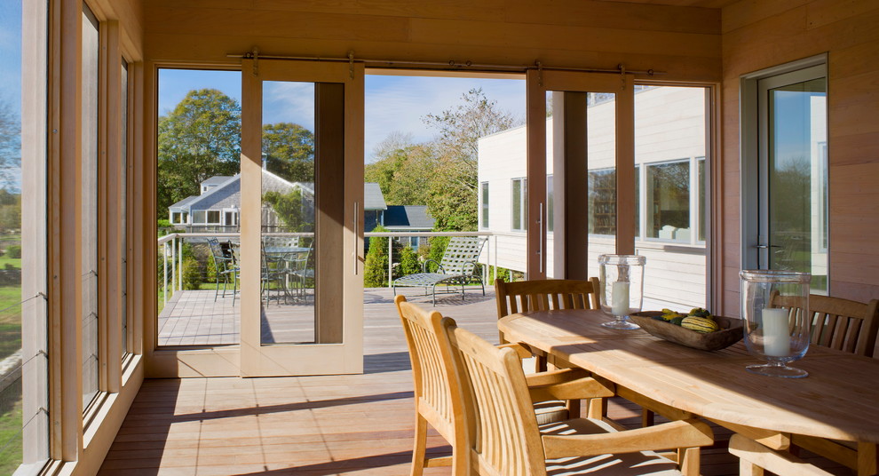 Esempio di una veranda design con pavimento in legno massello medio