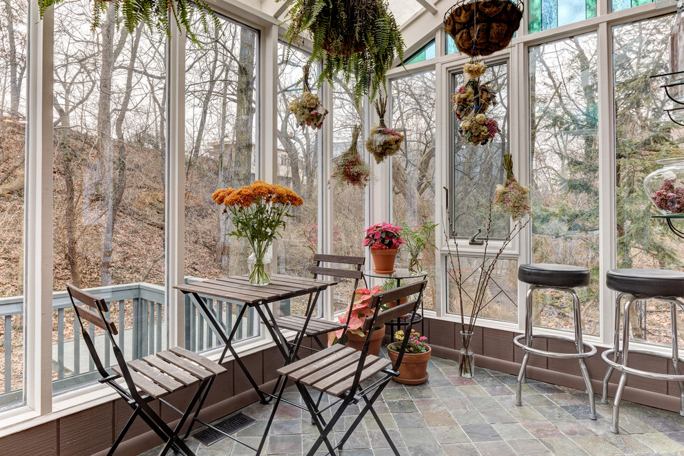 Foto di una veranda eclettica con pavimento in ardesia e soffitto in vetro