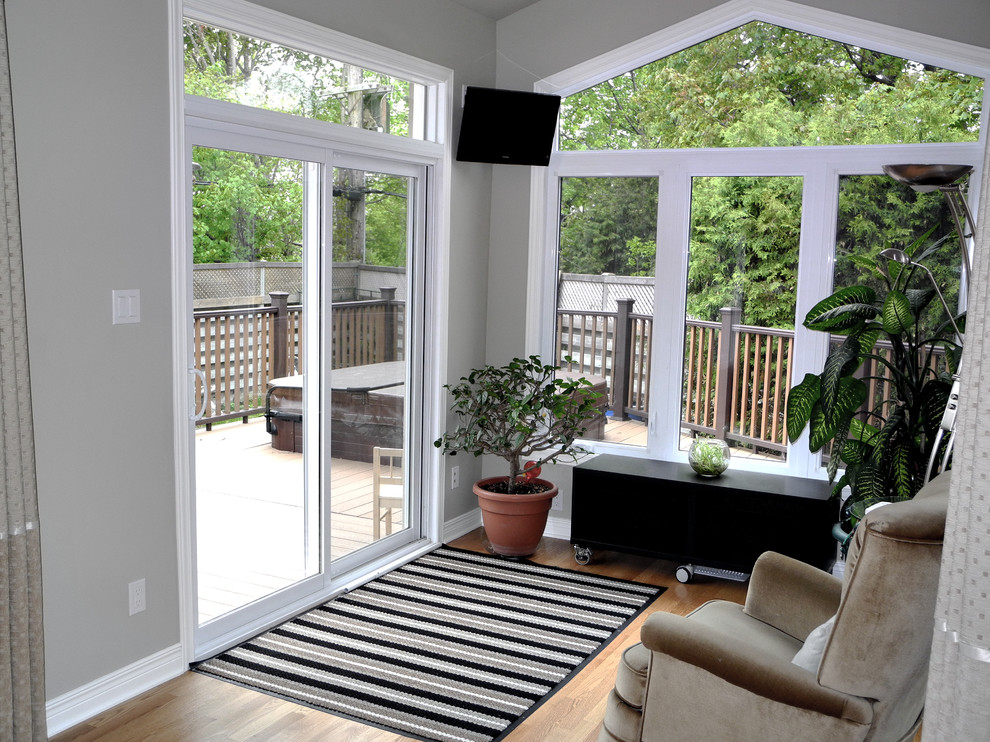 Immagine di una veranda design di medie dimensioni con pavimento marrone