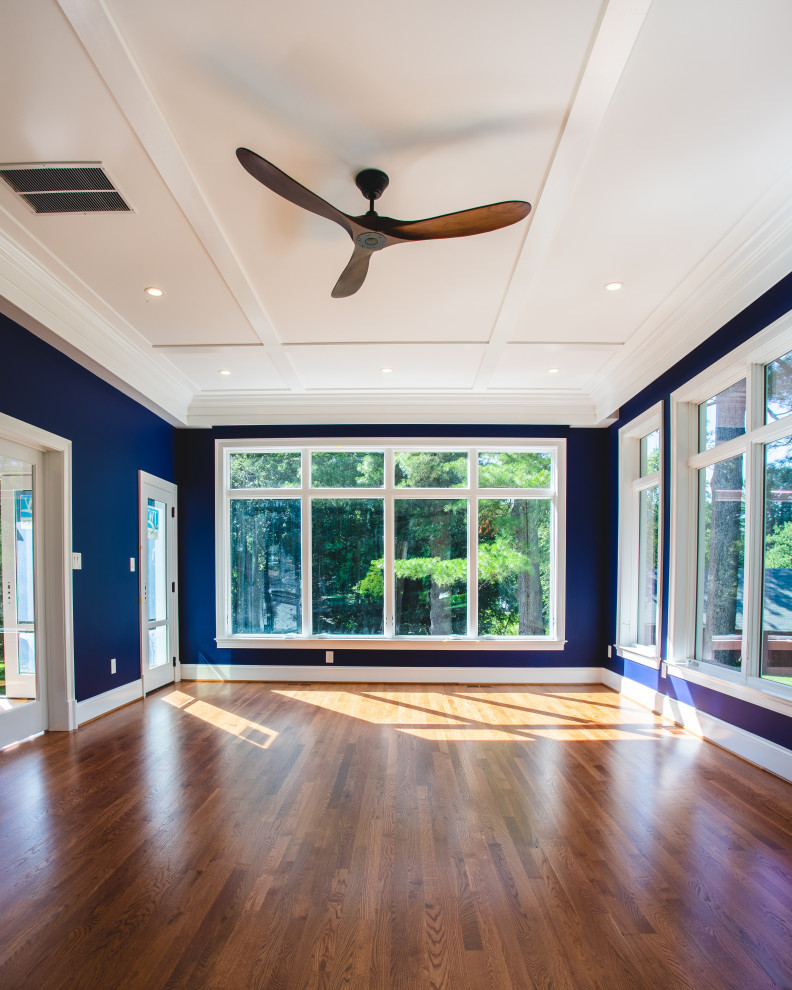 Photo of an expansive traditional conservatory in DC Metro with medium hardwood flooring, a standard ceiling and brown floors.