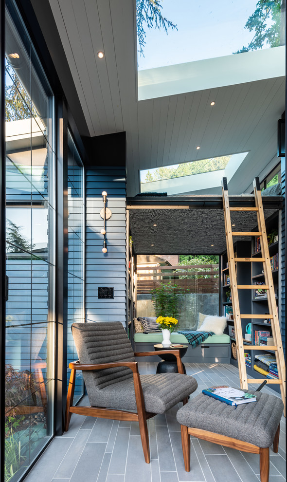 Foto di una veranda design con lucernario e pavimento grigio