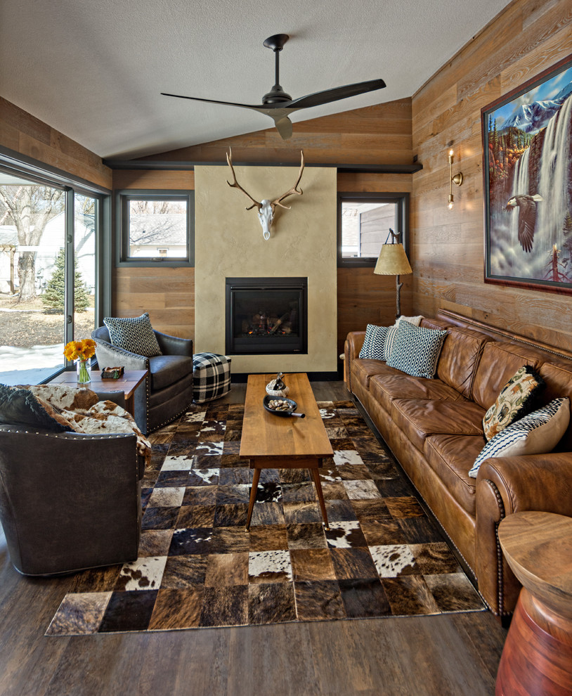 This is an example of a medium sized rustic conservatory in Minneapolis with vinyl flooring, a standard fireplace, a plastered fireplace surround, a standard ceiling and black floors.