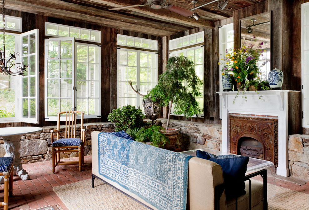 Idée de décoration pour une véranda champêtre avec un sol en brique, une cheminée standard, un plafond standard et un sol rouge.