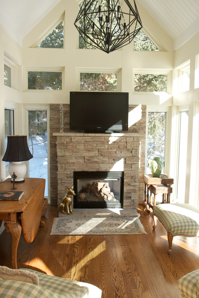 Exemple d'une petite véranda chic avec parquet foncé, une cheminée standard, un manteau de cheminée en pierre et un plafond standard.