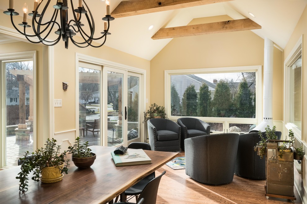 Immagine di un'ampia veranda classica con pavimento in legno massello medio, stufa a legna, pavimento marrone e soffitto classico