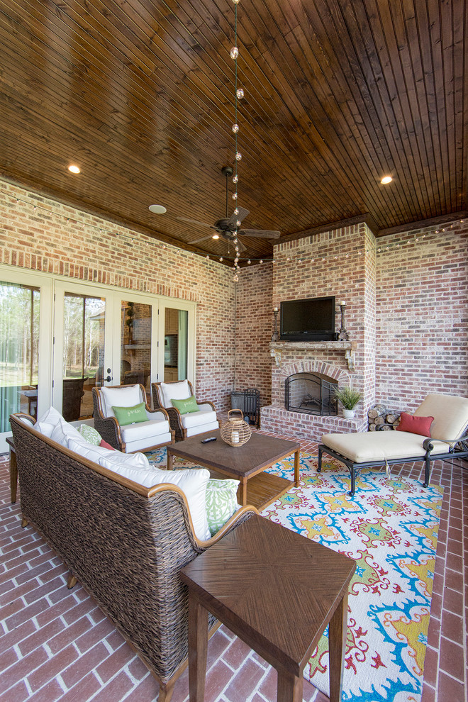 Esempio di una grande veranda tradizionale con pavimento in mattoni, camino classico, cornice del camino in mattoni e soffitto classico