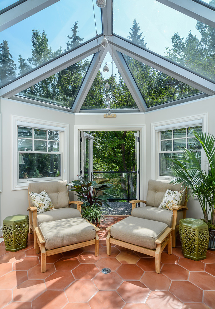 Foto di una veranda chic di medie dimensioni con pavimento in terracotta e soffitto in vetro