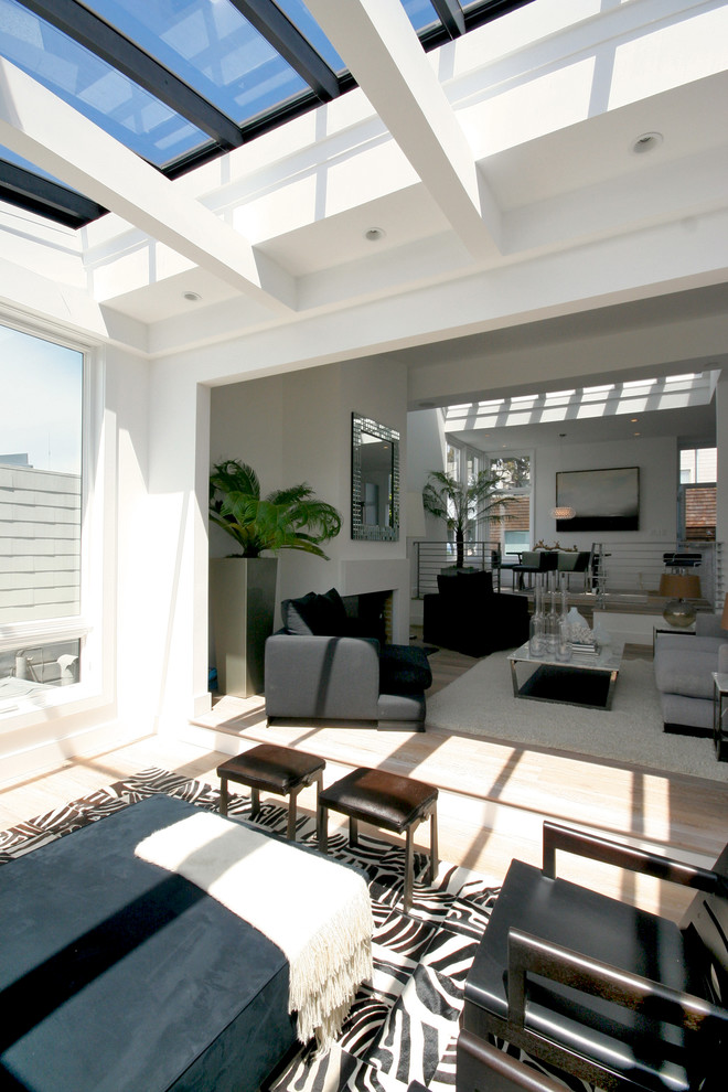 Cette image montre une véranda minimaliste avec parquet clair et un plafond en verre.