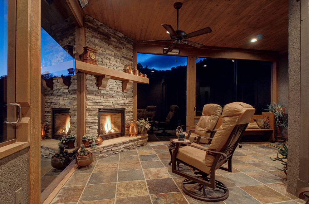 デンバーにある広いトランジショナルスタイルのおしゃれなサンルーム (テラコッタタイルの床、コーナー設置型暖炉、石材の暖炉まわり、標準型天井) の写真