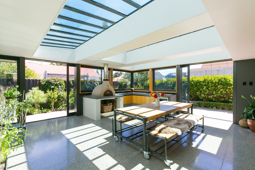 Источник вдохновения для домашнего уюта: терраса среднего размера в стиле модернизм с бетонным полом, печью-буржуйкой, фасадом камина из бетона, потолочным окном и серым полом