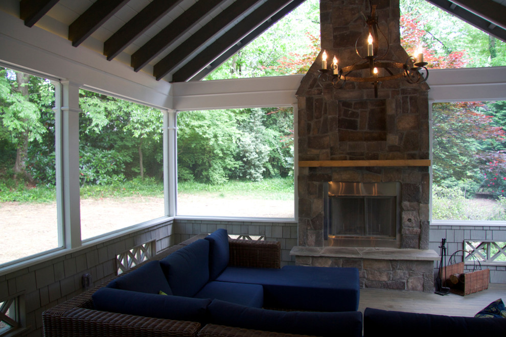 Immagine di una veranda american style di medie dimensioni con parquet scuro, camino classico, cornice del camino in pietra, soffitto classico e pavimento marrone