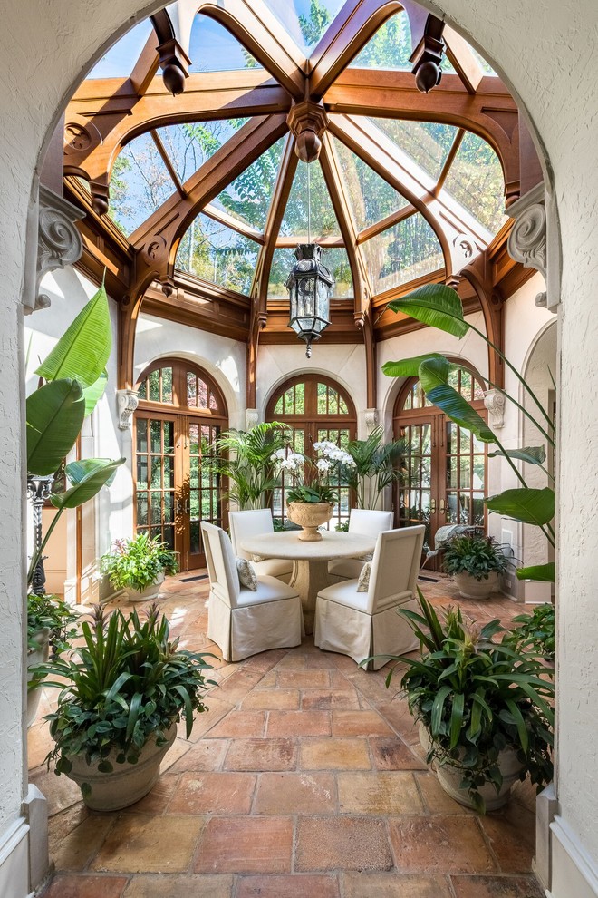 Photo of a traditional conservatory in Atlanta with brick flooring, a glass ceiling and red floors.