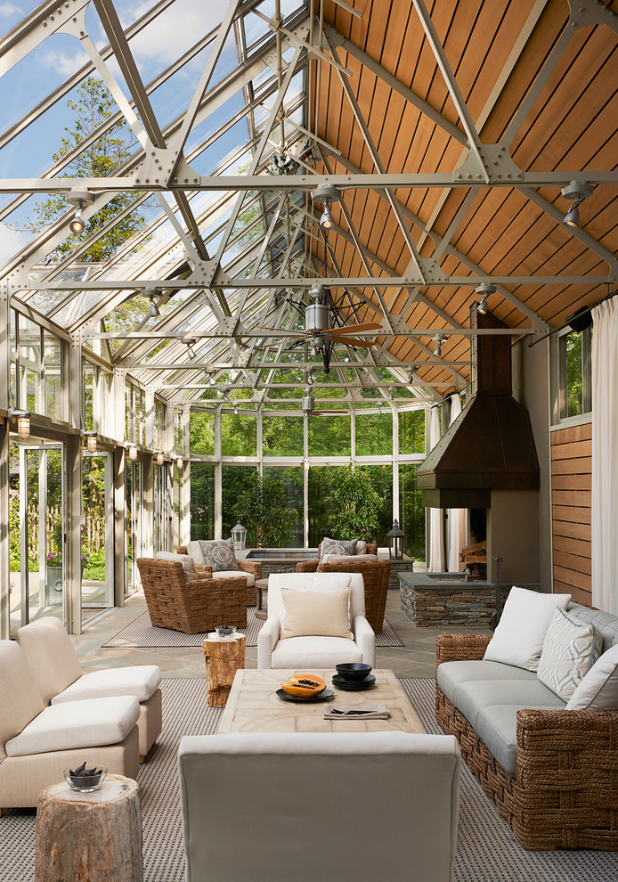Пример оригинального дизайна: терраса в стиле неоклассика (современная классика) с стандартным камином и стеклянным потолком