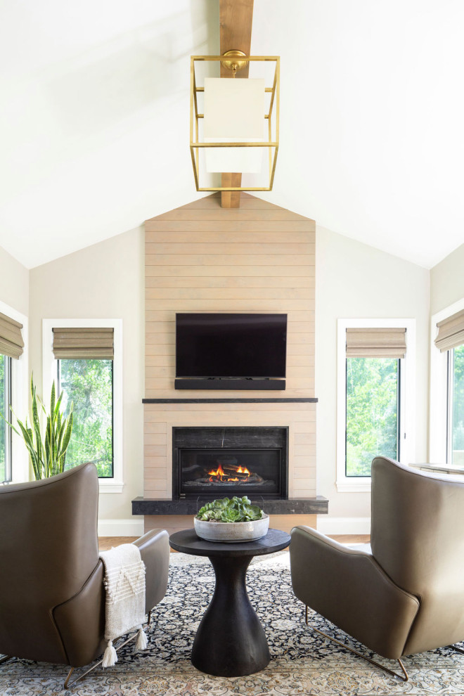 Aménagement d'une véranda classique de taille moyenne avec un sol en bois brun, une cheminée standard, un manteau de cheminée en lambris de bois et un sol beige.